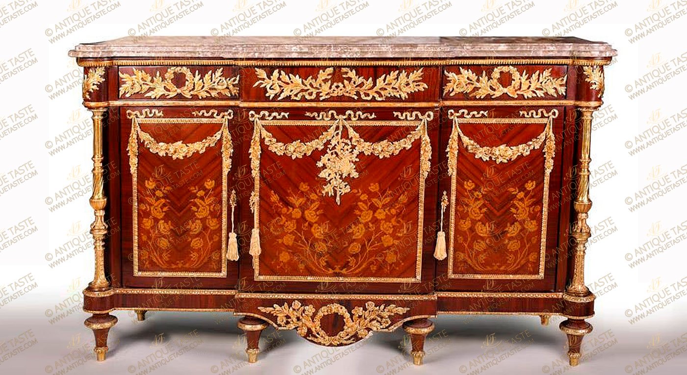  Sumptuous French Louis XVI style ormolu-mounted veneer and marquetry inlaid commode a vantaux after the model Frédéric Durand et Fils, based on a model by Martin Carlin, Paris, Last Quarter 19th Century,The breakfront shaped eared marble top above a conforming case set with frieze drawers ornamented with swags and ribbon-tied loose bouquets pierced interlaced laurel garlands over three cupboard doors inlaid with naturalistic flowers marquetry patterns, the paneled doors hung with ormolu blossoming pendant garlands, the sides similarly decorated, The angles with astonishing gilt-ormolu turned fluted colonnettes angle supports called 